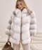 Woman wearing a voluminous Arctic Crossed fox fur coat, showcasing luxurious natural gradient hues and timeless elegance.