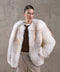 Wrapped in a voluminous genuine fox fur coat, a woman showcases rich golden hues and supreme warmth, ideal for -25ºC winter conditions.