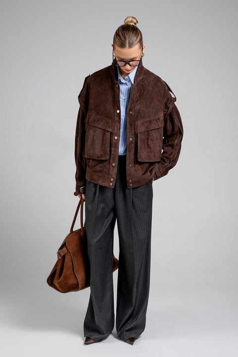 A model wears this dark brown suede jacket, combining trendy style with everyday practicality in a soft, high-quality leather design.