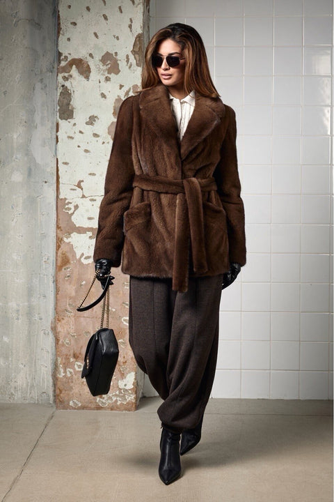 Model wearing a belted Brown Short mink fur coat with stylish sunglasses, showcasing luxury and elegance.